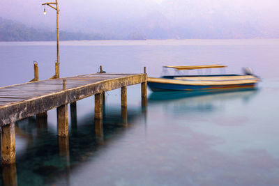 Wooden pier on lake against sky