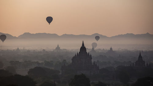 Hot air balloons against sky during sunset