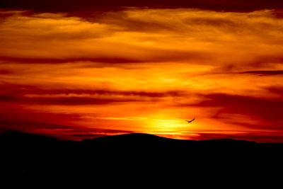 Silhouette of mountain against dramatic sky