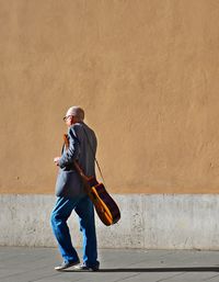 Full length of man standing against wall