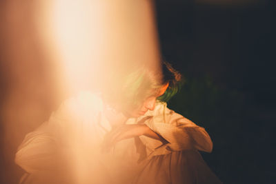 Portrait of woman sitting in low light