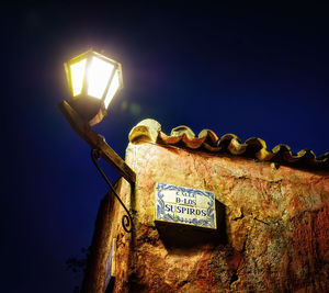 Low angle view of illuminated street light against sky