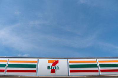 Low angle view of multi colored flag against blue sky