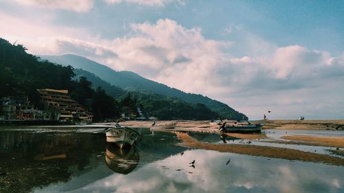 Scenic view of lake by mountains against sky