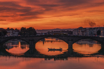 Bridge over river against sky during sunset