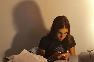 Side view of young woman using mobile phone at home