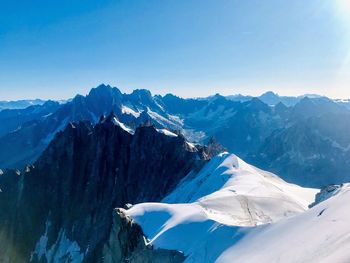 Scenic view of snowcapped mountains against clear blue sky