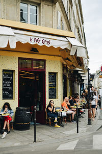 People at sidewalk cafe in city