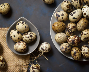 Quail eggs on a black table.