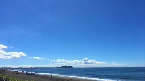 Scenic view of beach against blue sky