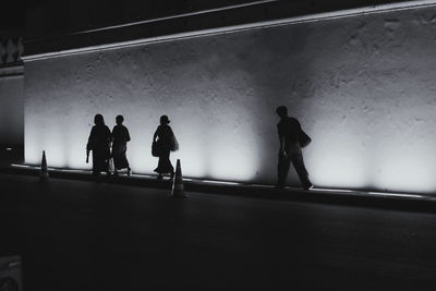 Silhouette people walking in corridor of building