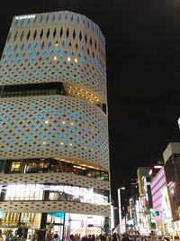 Low angle view of illuminated skyscraper against sky at night