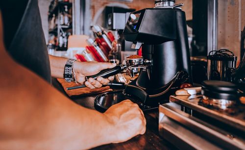 Midsection of man using coffee machine