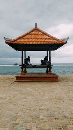 Lifeguard hut on beach against sky