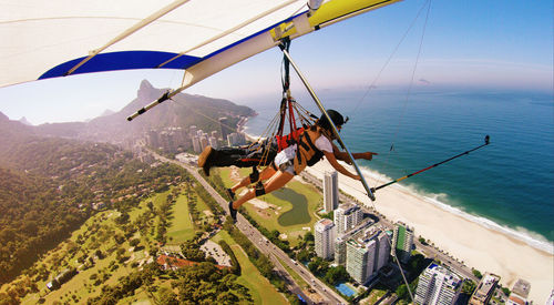 High angle view of people hang gliding over landscape