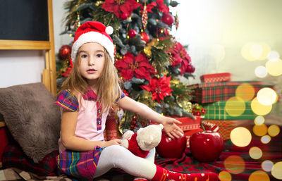 Portrait of woman sitting in christmas tree
