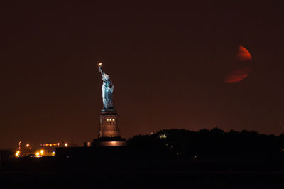 Statue of illuminated city at night