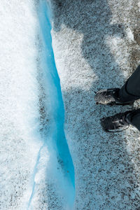 Low section of person standing on snow