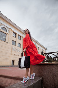 Full length of woman standing against built structure