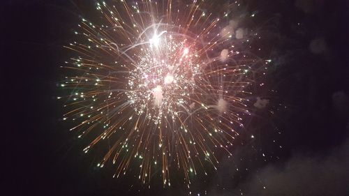 Low angle view of firework display at night