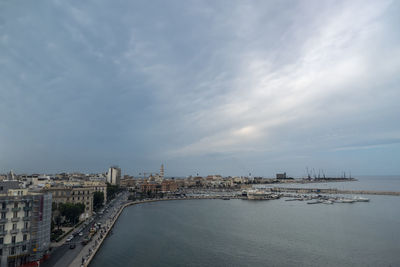 Bridge over sea against buildings in city