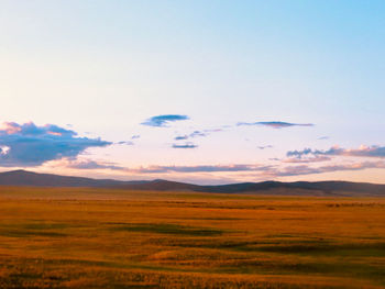 Scenic view of field and mountains against sky