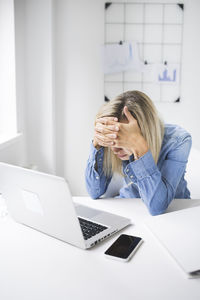 Frustrated businesswoman sitting at office