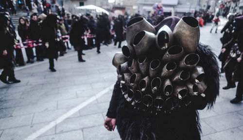 Rear view of person selling bells in city