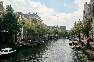 Canal amidst buildings against sky in city