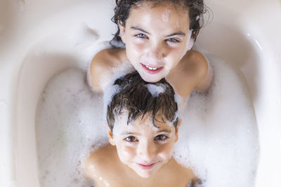 High angle portrait of smiling siblings in bathroom