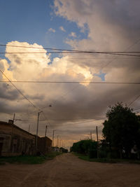 Road amidst trees against sky during sunset