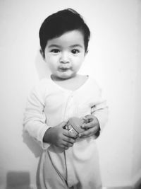 Portrait of cute boy standing against wall