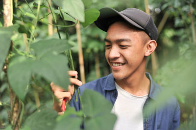 Happy of young asian farmer male looking at the long beans