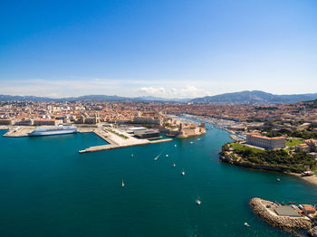 High angle view of harbor and bay against blue sky