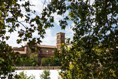 Low angle view of trees and building against sky