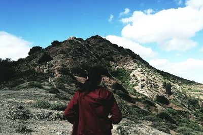 Man with umbrella against sky