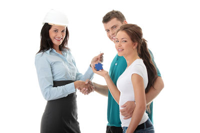 Young couple holding hands against white background