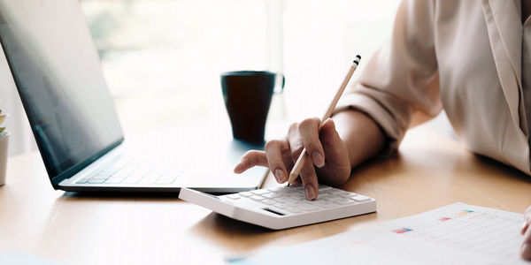 Midsection of man using laptop on table