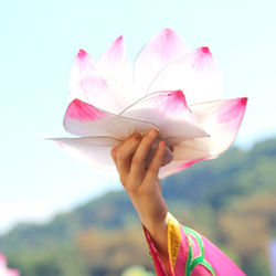 Cropped hand holding paper flower 