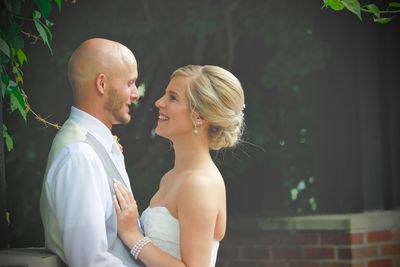 Side view of young couple looking each other face to face while standing outdoors