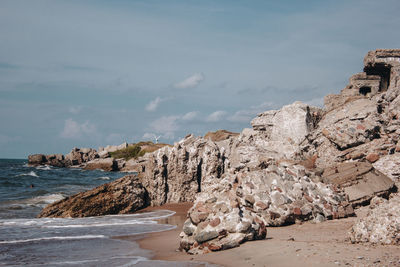 Rocks on beach against sky