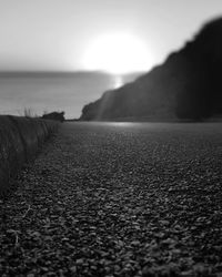 Surface level of road by sea against sky