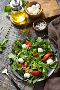 Healthy diet salad with arugula, mozzarella, mussels and vinaigrette dressing. low calories meal.