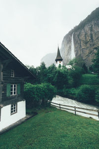 Buildings and waterfall against clear sky