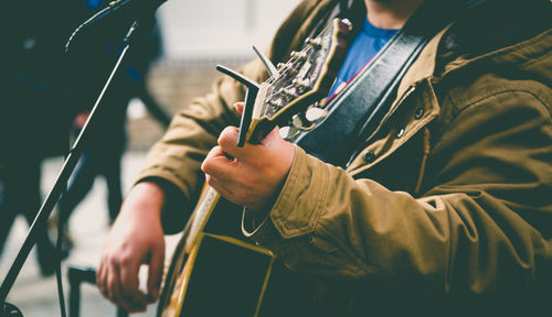 Close-up of man playing guitar