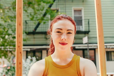 Portrait of a young woman sitting in an outdoor patio.