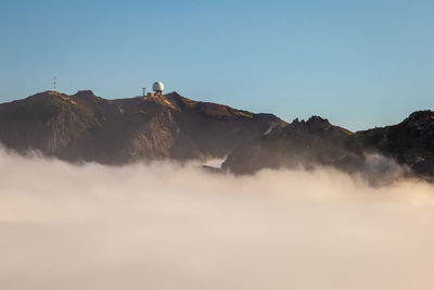 Low angle view of built structure on mountain against sky