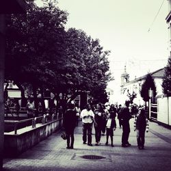 Rear view of people walking on street in city