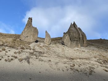 Low angle view of rock formations on landscape against sky