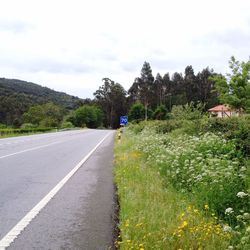 Country road against cloudy sky